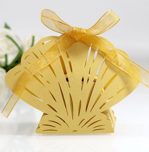 Detailed laser-cut seashell candy box in golden pearlescent paper with a matching ribbon bow