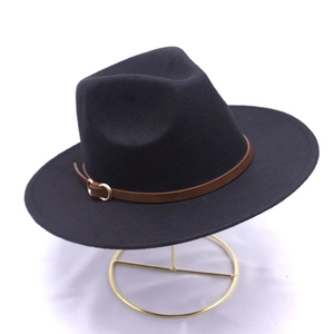 Dettaglio del cappello fedora in lana nera con cinturino in pelle e fibbia d'oro