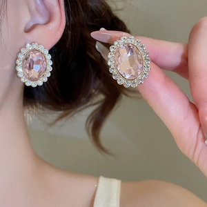 Close-up of elegant pink oval crystal stud earrings with a halo of sparkling pavé diamonds
