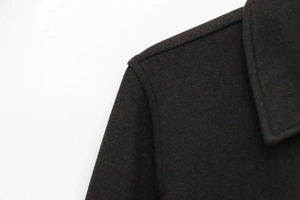 Detailed shot of dark grey wool coat shoulder seams and notched lapel texture