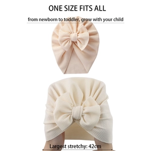 Elastic baby bow turban hat in beige rib knit fabric, fits newborn to toddler