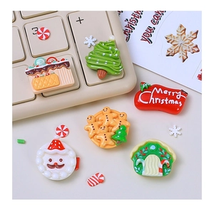 Flat lay of Christmas resin charms including Santa, gingerbread man, and tree for DIY crafts