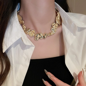 Close-up of golden irregular metal necklace set on a model with a minimalist luxury aesthetic