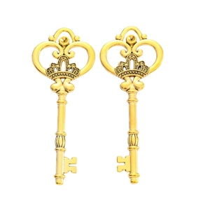 Detailed view of two vintage golden crown key charms for DIY jewelry and crafts