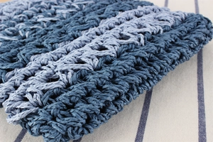 Close-up of blue and white striped handwoven straw bag showing detailed natural texture