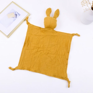 Macro shot of ginger yellow cotton gauze baby comforter featuring a soft bunny head detail