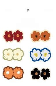 Detailed grid of six flower-shaped bathroom mats in multiple colors with artistic lettering