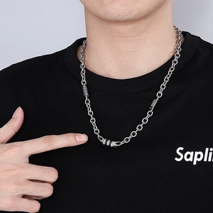 Detail of silver stainless steel chain necklace with spring textured connector on model