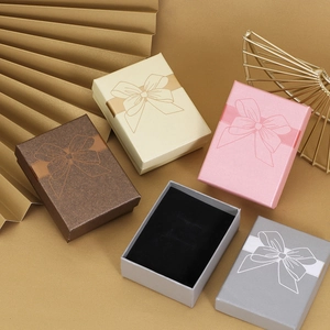 Elegant jewelry gift boxes with bow patterns in brown, beige, and pink tones