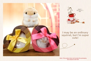 Detail of cute plush hamster doll next to heart-shaped gift boxes for holiday gifting