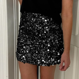 Detailed view of women's elegant black sequin mini skirt with shimmering circular finish