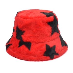 Detailed texture of red faux fur bucket hat with black star patterns for winter warmth
