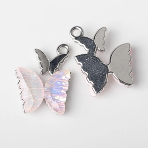Detail of pink resin butterfly charms with silver metal base for DIY jewelry making