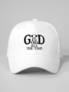 Dettaglio macro del ricamo nero 'GOD IS GOOD' su un cappellino in cotone bianco