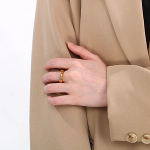 Detail of a minimalist gold irregular stainless steel ring worn on a finger