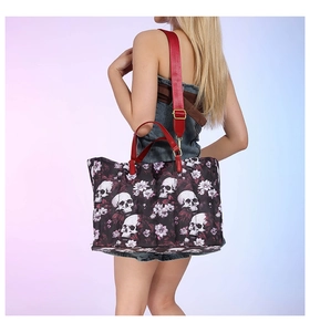 Detail of printed skull and floral tote bag with red handles and wide shoulder strap