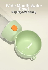 Detail of portable pet water bottle with a 90mm wide green drinking trough and orange button