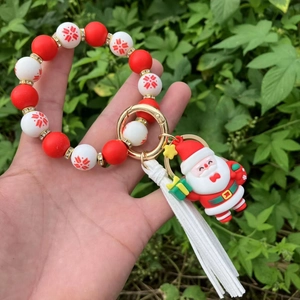 Detail of red and white silicone beaded keychain with Santa charm and white tassel