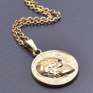 Macro detail of 18k gold plated skull relief pendant with durable titanium steel link chain
