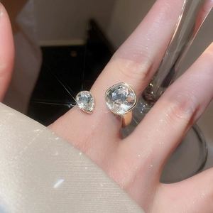 Close-up of gold adjustable ring with sparkling pear and square cut zircon stones