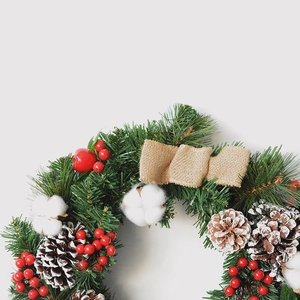 Classic Christmas pine wreath with red berries, pine cones and a burlap bow decoration