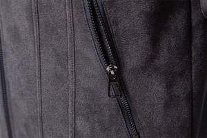 Macro shot of charcoal grey suede jacket featuring a metal zipper pocket and fine stitching
