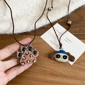 Detailed view of adjustable leather cord necklaces with leopard cat paw and puppy charms