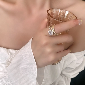 Detail of a double-layered gold ring with a sparkling oval zircon and pavé diamonds