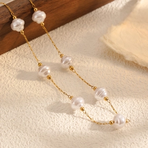 Macro detail of irregular baroque pearls and 18k gold plated stainless steel necklace chain