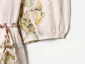 Detail view of floral print linen top with elastic cuffs and drawstring waist textures
