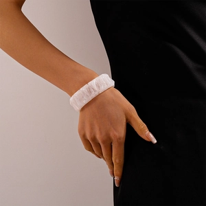 Detail of chunky resin geometric bangle with marbled white texture on model wrist