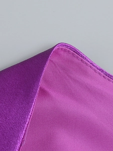 Detailed close-up of purple satin dress fabric showing precise stitching and silky texture