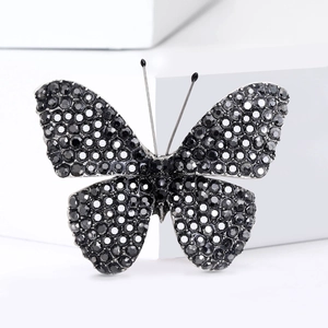 Macro shot of silver-toned butterfly brooch featuring sparkling black faceted rhinestones