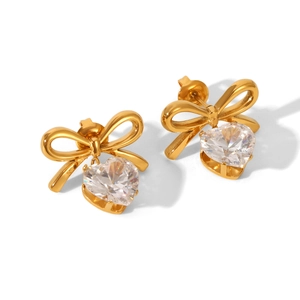 Golden bow heart earrings with sparkling cubic zirconia on a white background
