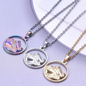 Detailed view of 18K gold and silver mountain relief pendants in multiple metallic finishes