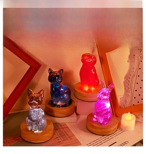 Silicone animal mold creations with cat and rabbit shapes on a lighted wooden base