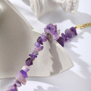 Macro view of natural purple amethyst beads with elegant gold-plated metallic clasp