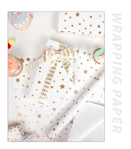 Detail of white gift wrapping paper with gold stars and decorative gift box packaging