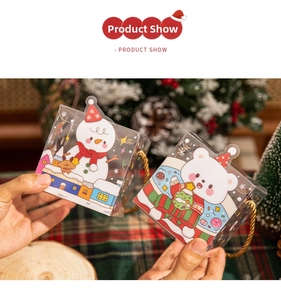 Close-up of Christmas PVC gift boxes with snowman and bear illustrations and gold handles