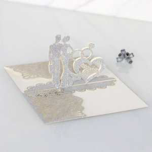 Close-up of 3D laser-cut Mr & Mrs pop-up wedding invitation with silver glitter lace details