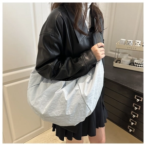 Detailed texture of light blue pleated dumpling bag made of soft nylon fabric