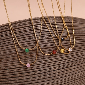 Detail of thin 18K gold-plated chains with six colorful zircon pendants on display