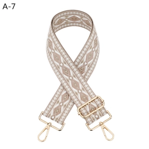 Detail of adjustable geometric diamond pattern bag strap with gold metal lobster hooks