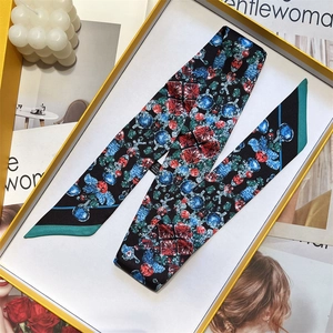 Flat lay of silk scarf with red and blue jewel pattern in a luxury white gift box