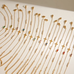 Vue détaillée de bracelets croix dorés ajustables avec diverses pierres en zircon coloré