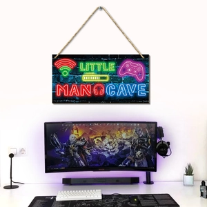 Detail of neon gaming wall plaque Little Man Cave sign on dark brick texture background