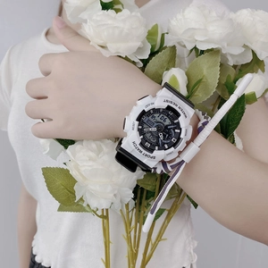 Detail of the dual-display sports watch with white case on wrist with flower