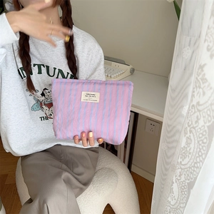 Detail of lavender striped canvas cosmetic bag with aesthetic woven label and soft texture