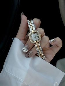 Gros plan d'une montre carrée bicolore avec lunette en cristal et cadran en nacre