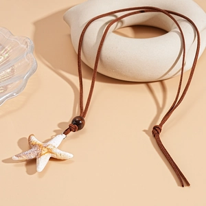 Detailed close-up of a starfish pendant with realistic texture on a brown suede cord